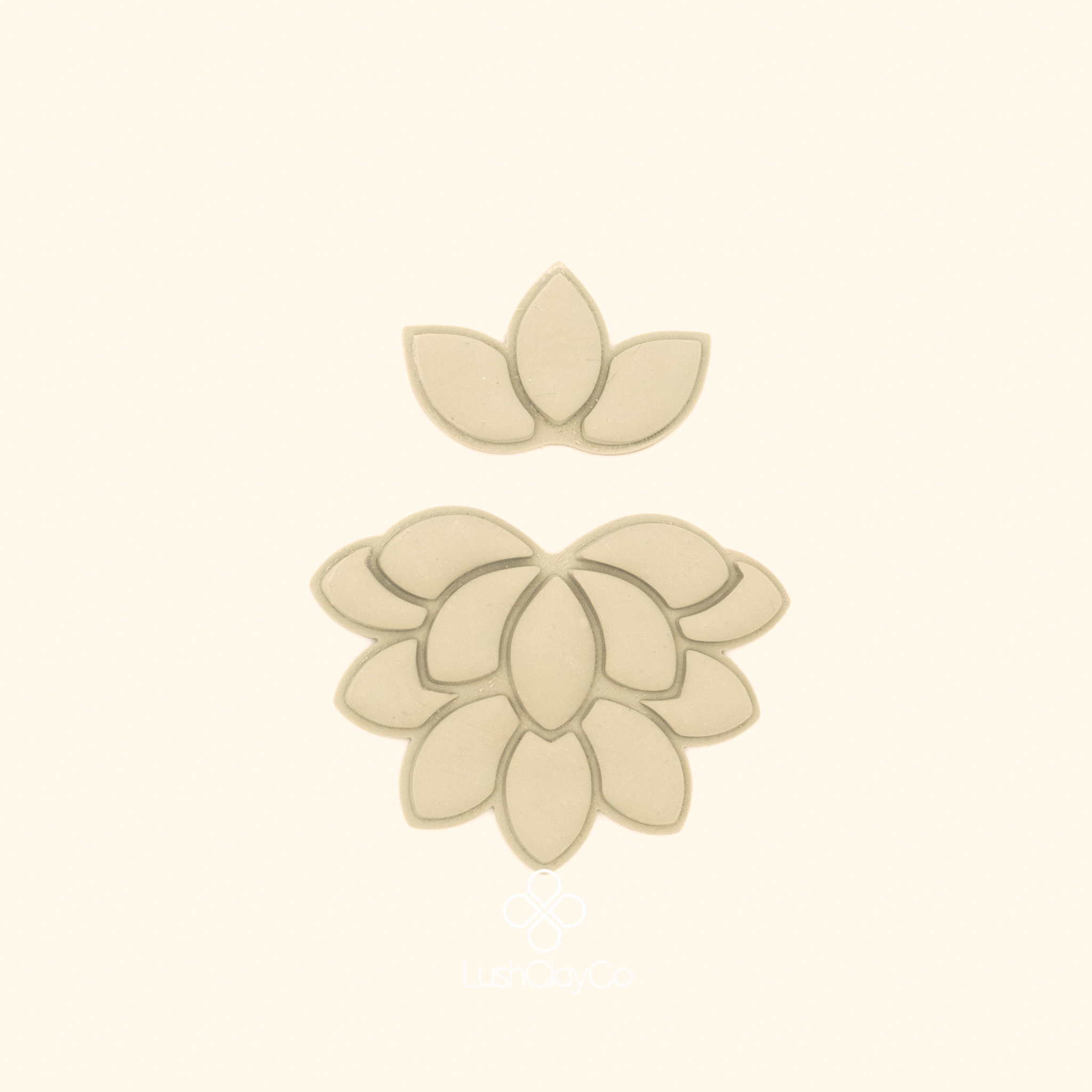 Clay impressions of the Nilüfer Deste botanical cutter set showing tiered lotus bloom and three petal crown form pressed into polymer clay