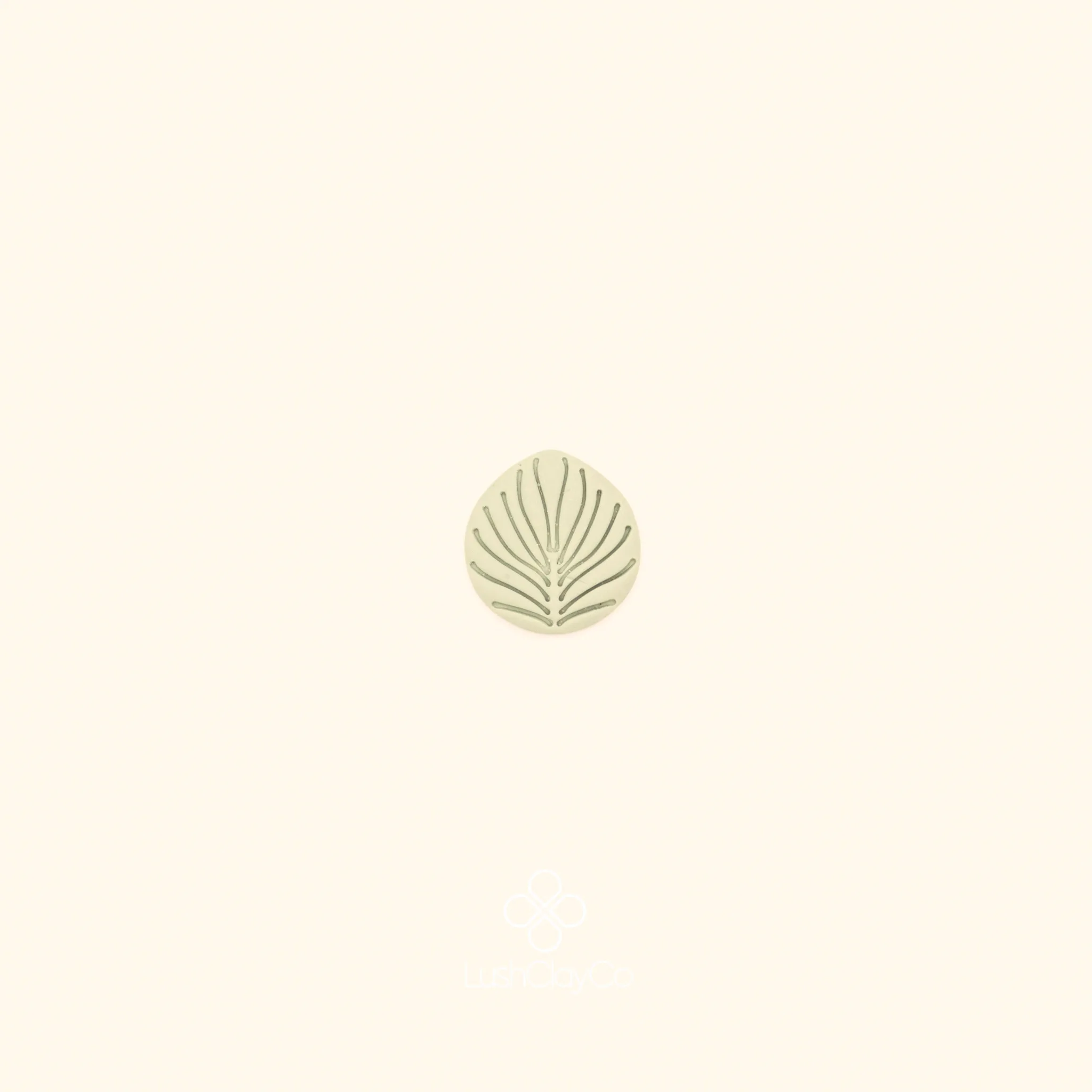 Clay impression of the Ritim Palmet cutter showing fan-shaped palmet form with radiating line detail pressed into polymer clay