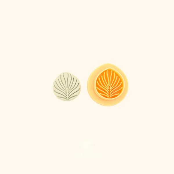 Ritim Palmet palmet polymer clay cutter alongside clay impression showing single rounded fan leaf form with fine radiating lines from a central stem