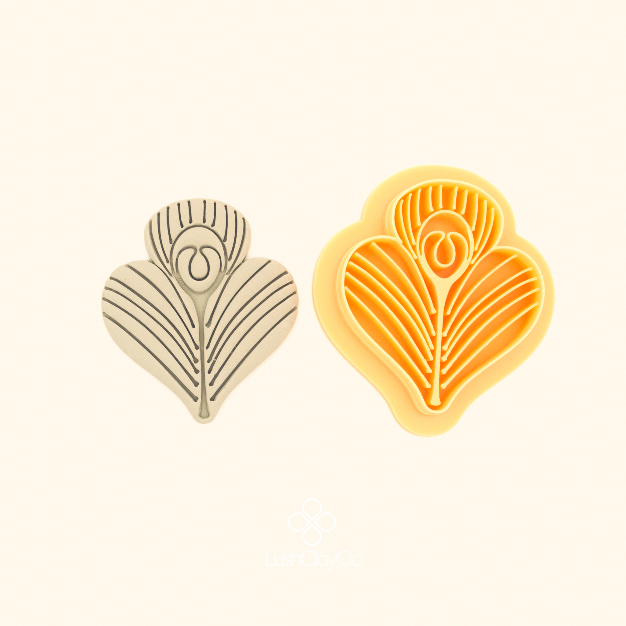 Tavus Tüyü peacock feather polymer clay cutter alongside clay impression showing wide heart silhouette with dense radiating lines and oval eye