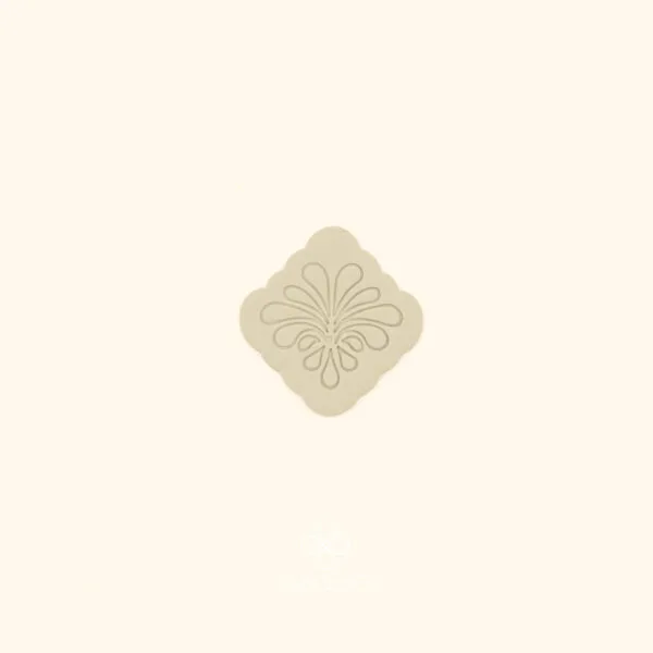 Clay impression of the Zümrüt Fan rumi cutter showing symmetrical teardrop arabesque spray pressed into polymer clay within a rounded square frame
