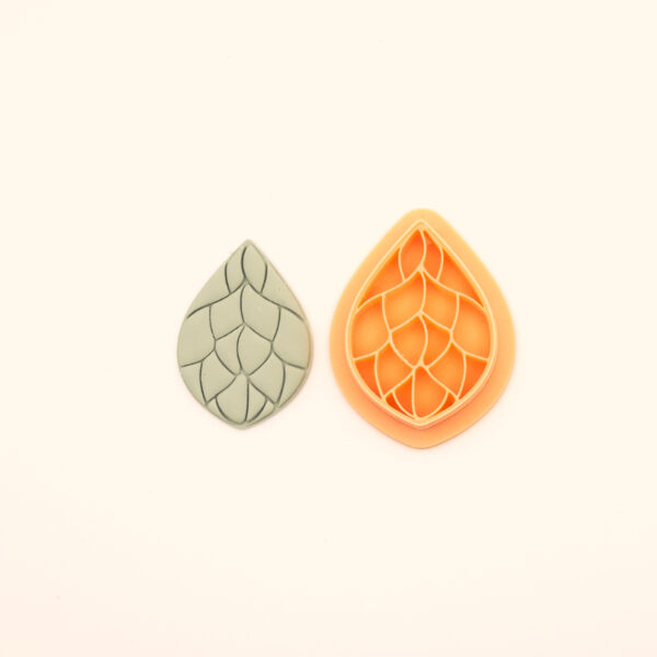 Damar Damla rumi polymer clay cutter alongside clay impression showing teardrop silhouette with bold curving vein channels dividing the interior into open sections