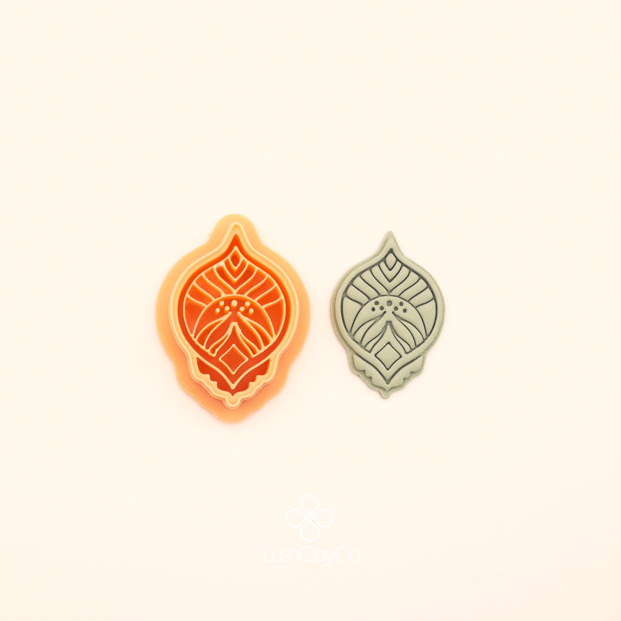 Zerrin hatayi polymer clay cutter alongside clay impression showing pointed oval silhouette with central diamond form, curved leaf detail and dot clusters