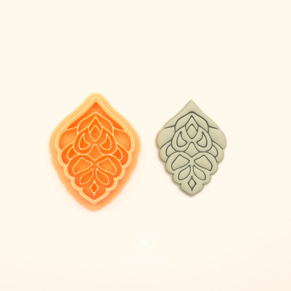 Haşmet hatayi polymer clay cutter alongside clay impression showing pointed ogival silhouette with dense symmetrical layered teardrop and petal cluster interior