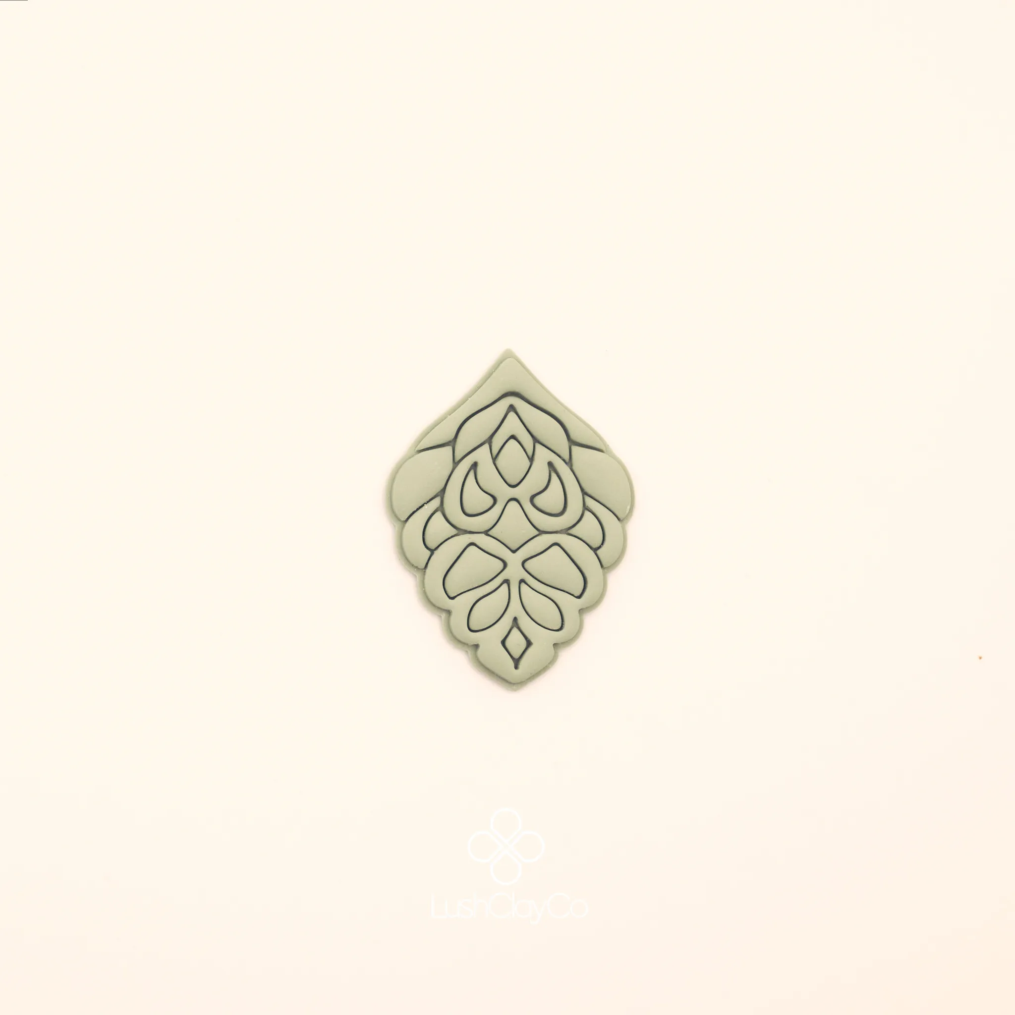 Clay impression of the Haşmet hatayi cutter showing dense symmetrical interior with teardrop clusters and central vertical column pressed into polymer clay