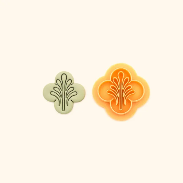 Selsebil ottoman polymer clay cutter alongside clay impression showing four lobed clover silhouette with central fountain spray and flanking curved line detail