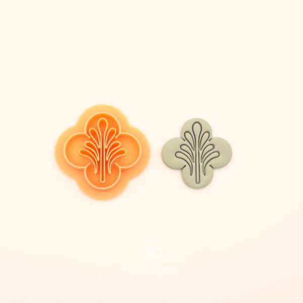 Selsebil ottoman polymer clay cutter alongside clay impression showing four lobed clover silhouette with central fountain spray and flanking curved line detail