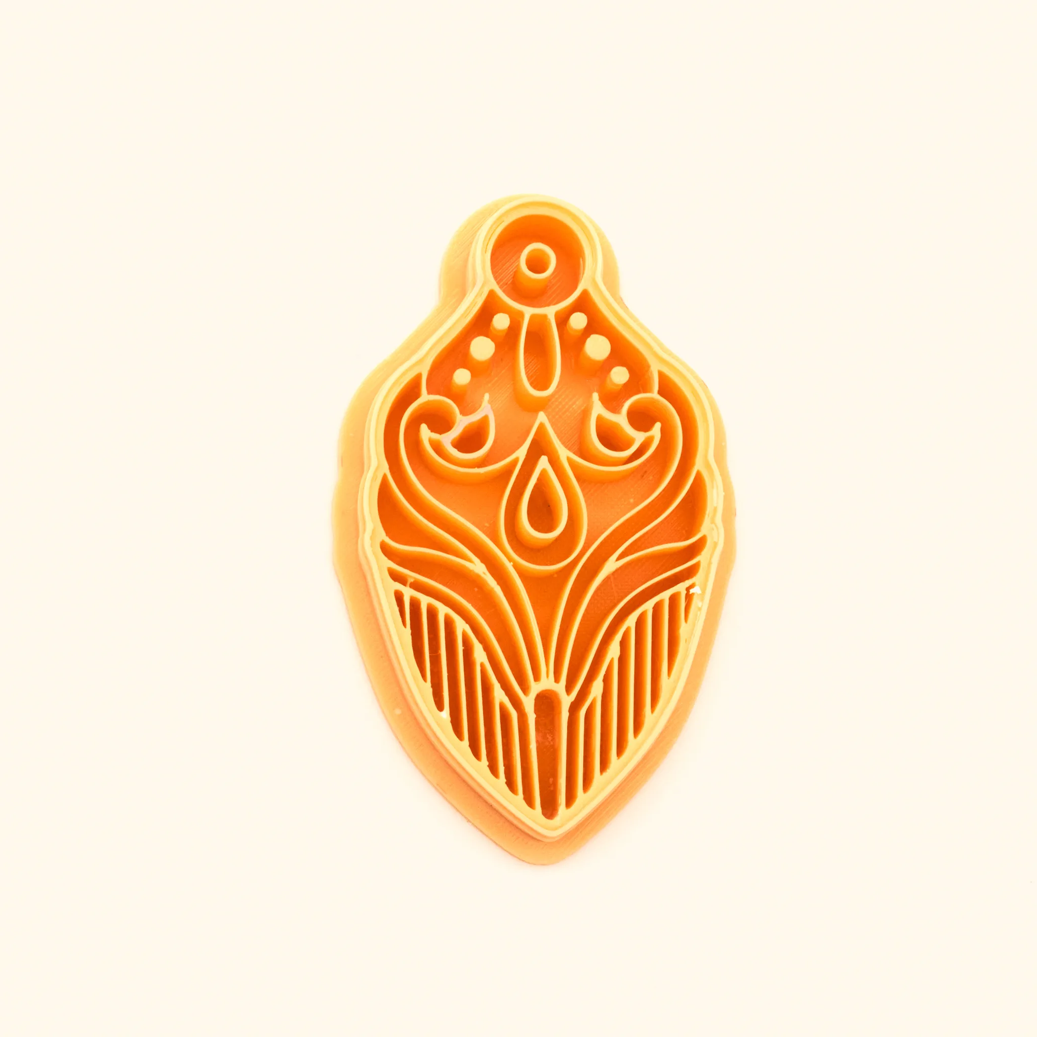 Şebnem cutter, a winged rumi-scroll pendant with a central teardrop